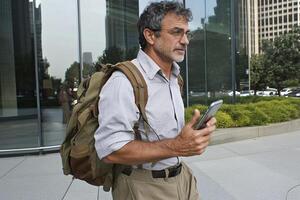 A man with a backpack and a phone photo