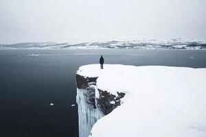 A person standing on top of a cliff overlooking the ocean photo