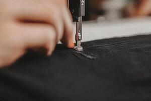 A person is sewing a piece of fabric photo
