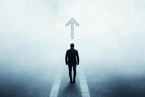 A man standing on a road with an arrow pointing up photo
