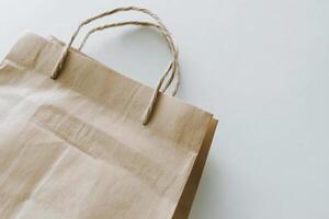 A brown paper bag with a handle on a white surface photo