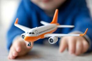 A child holding a toy airplane on a table photo