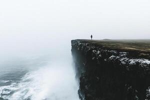 A person standing on the edge of a cliff photo