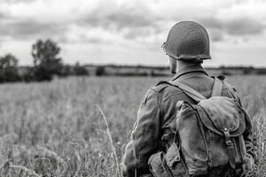 A soldier in a field with a backpack photo