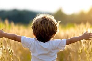A child standing in a field with their arms outstretched photo