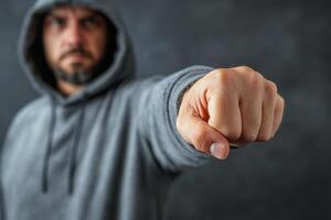 A man in a hoodie pointing at something photo