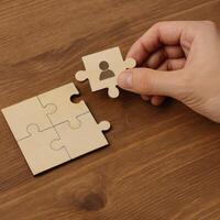 Selecting Person and Building Team Concept with Jigsaw Puzzle Piece on Wooden Table, Symbolizing Human Resource Management and Teamwork photo
