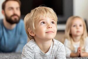 A little boy is looking up at the camera while his parents are in the background photo