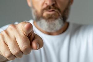 A man with a beard pointing at something photo