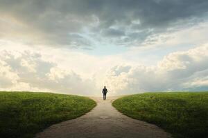 A man walking down a path in a field photo