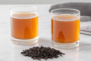 Two glasses of tea with a tea bag on the table photo