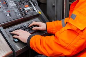 A person in an orange jacket is typing on a keyboard photo