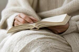 A person is reading a book while wrapped in a blanket photo