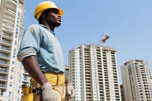 A man in a hard hat standing in front of a building photo