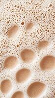 Warm beverage topped with creamy foam displays abundant bubbles, inviting drinkers to enjoy a comforting experience in a quaint cafe atmosphere photo