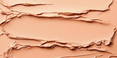 Various textured layers of beige foundation display intricate patterns. The warm tones and smooth surface combine for a creative, abstract effect in beauty products photo