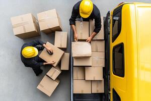 Two men in hard hats loading boxes onto a truck photo