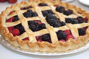 A pie with berries on top and a lattice pattern photo