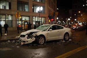 A white car is damaged in the middle of the road photo
