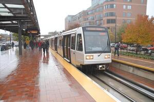 A train is pulling into a station with people on the platform photo