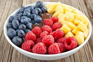 A bowl of fruit and a chocolate pudding photo