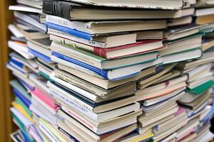 A pile of books is shown in front of a bookcase photo