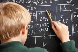 A boy writing on a blackboard with math on it photo