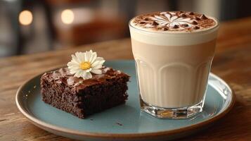 Decadent chocolate brownie paired with a creamy latte, garnished with a flower photo