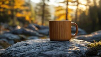 Wooden mug rests on a rock in a sunlit autumnal forest photo