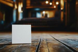 A white card is sitting on a wooden floor photo