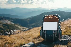A backpack is sitting on a grassy hillside with a white sign on the back photo