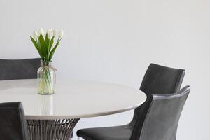 The tulips flowers in the vase add a touch of elegance to the table. photo
