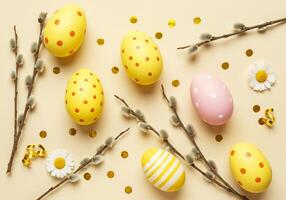 Easter eggs with polka dots and twigs on a yellow background photo