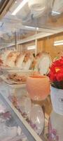 Side view of multiple ceramic plates and mug on displays in dishware store. photo