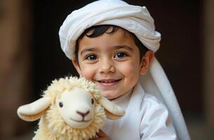 Cheerful boy with plush toy lamb in traditional middle eastern attire. Eid al Adha photo