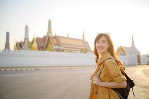 A woman in a yellow jacket standing in front of a building photo