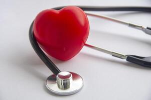 A Close up view of stethoscope and a red heart shape with customizable space for text. Medical and health concept photo