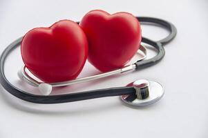 cerca arriba ver de estetoscopio y dos rojo corazones forma con personalizable espacio para texto. médico y salud concepto foto
