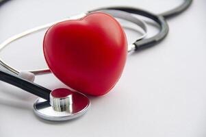 Close up view of stethoscope with red hearts shape on white background with customizable space for text. Medical and health concept photo