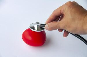 Top view of hand holding stethoscope and a red heart shaped with customizable space for text. Medical and health concept photo