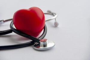 Close up view of stethoscope with red hearts shape on white background with customizable space for text. Medical and health concept. photo