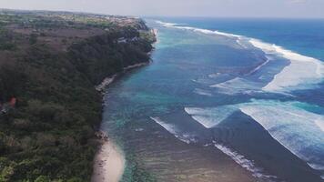 Aerial view of Bali beach with cliffs, turquoise ocean, and waves video