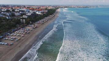 Aerial view of Kuta Beach with colorful umbrellas and ocean waves, Bali video