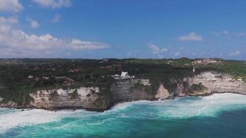 Clifftop temple and rugged coastline with crashing waves in Bali video