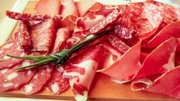 Assorted Italian cold cuts on a wooden platter. photo