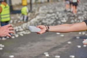 Young volunteer assisting a runner with a wet sponge at the Vigo-Bayona race in Nigran, Spain photo