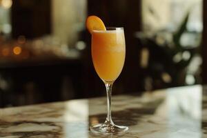 A glass of orange juice sitting on a bar photo