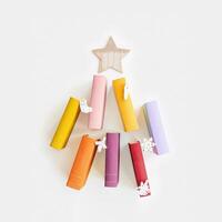 Christmas tree of colors paper books, New Year fir shape with wooden toys, colorful covers of books as holiday Christmas tree. Studying, education concept. Top view greeting card photo