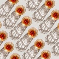 Whiskey Glasses with Shadows and sunlight Reflection on beige, glass strong alcohol, top view repeated pattern, aesthetic top view summer still life, refraction at crystal shine cups, caustics photo
