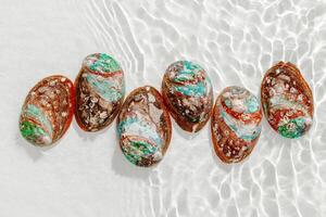 Set of abalone seashell floating on clear white water with sun glare and waves. Shells of natural iridescent and rough textures. Minimal style top view pattern sea ocean life background, copy space photo